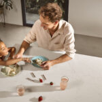 Family socialising at a Caesarstone Dreamy Carrara kitchen island