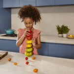Close up of a girl with Dreamy Carrara worktops in a family kitchen
