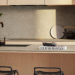 Close-up of Caesarstone Mosstone Porcelain kitchen island, worktops and splashback in a modern kitchen